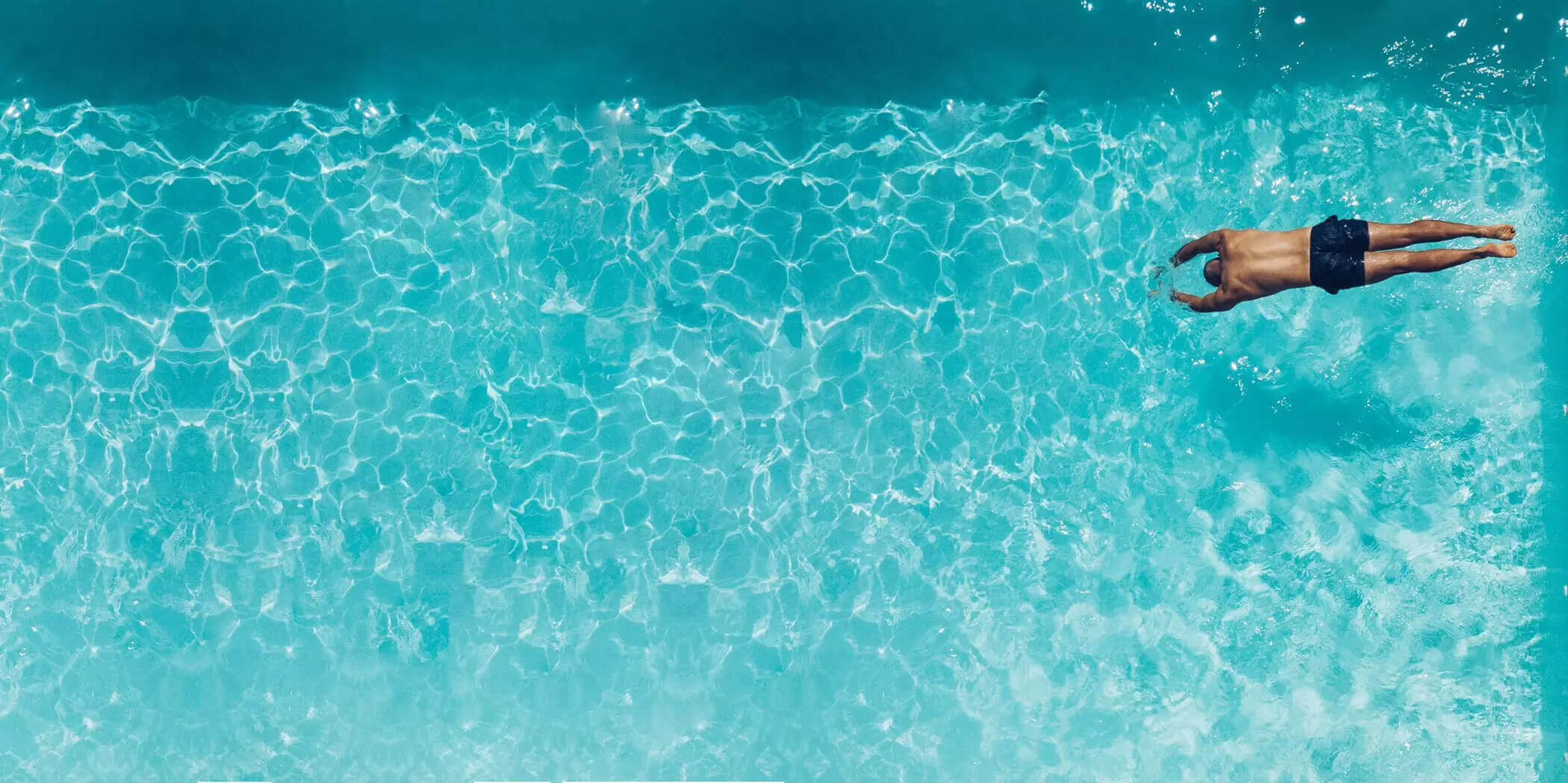 photo d'un homme plongeant dans une piscine, vue de dessus